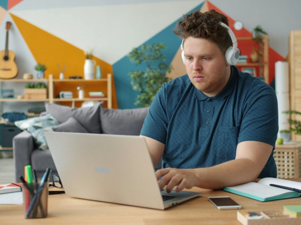 Person using a laptop and headphones for online learning