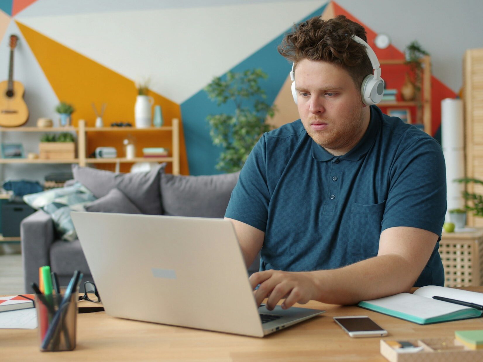 Person using a laptop and headphones for online learning